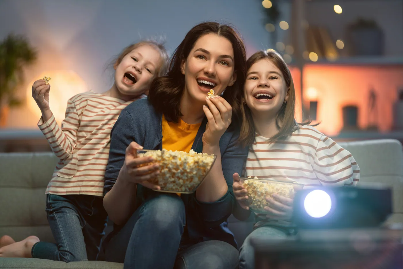A mother and two children enjoying a movie night together